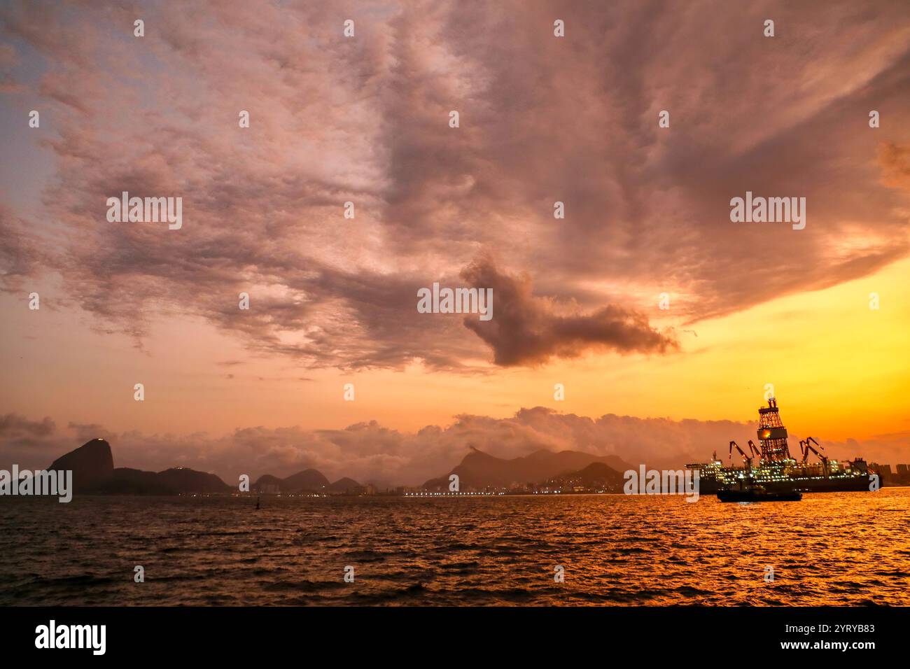 Le barche industriali sono viste al tramonto nella baia di Guanabara, Niterói di fronte a Rio de Janeiro. Foto Stock