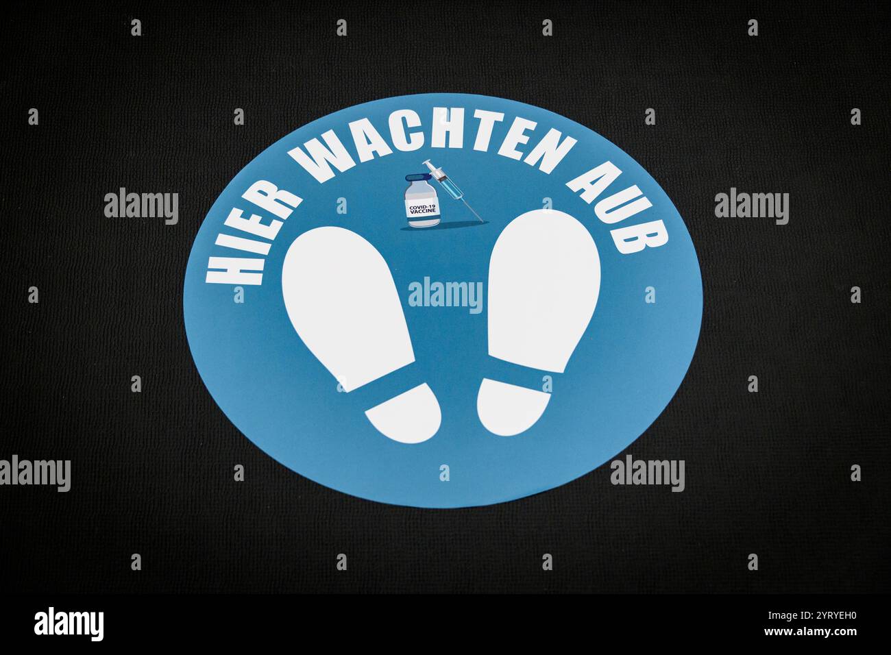 Segnaletica di distanziamento sociale in olandese, che indica alle persone di aspettare e utilizzare disinfettante per le mani, sottolineando le misure di igiene e sicurezza. Foto Stock