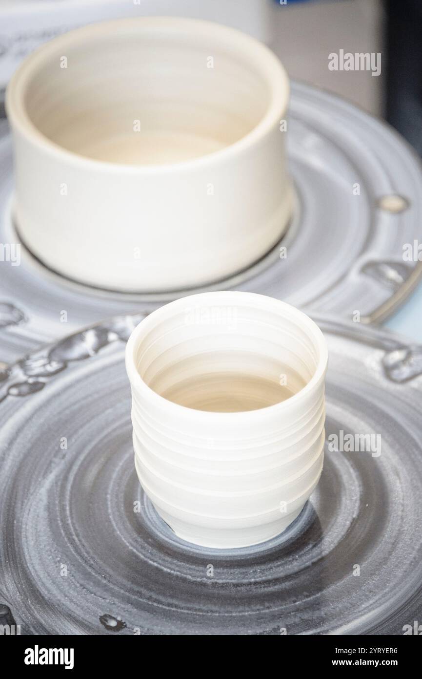 Modellare le mani sull'argilla su una ruota di ceramica, mettendo in risalto l'artigianato tradizionale, l'arte della ceramica e la produzione artigianale di ceramiche. Foto Stock
