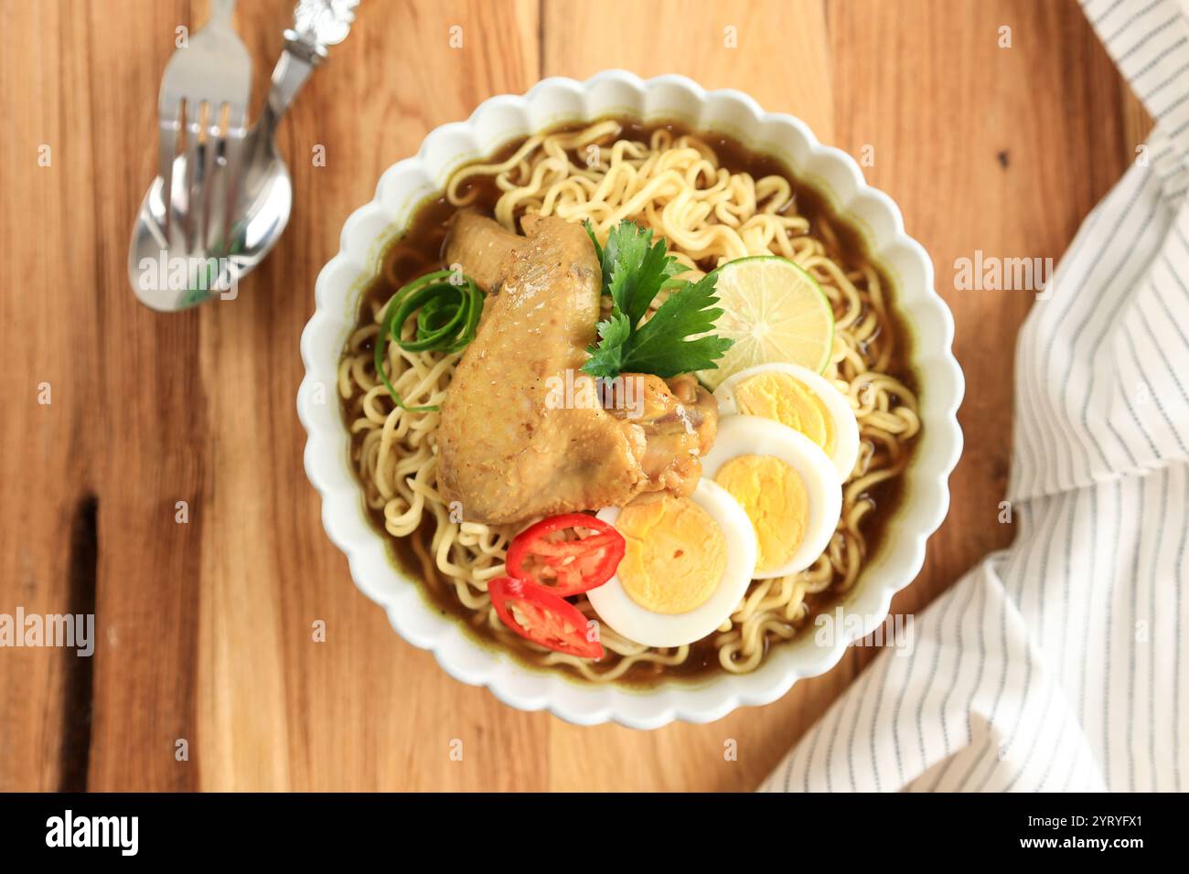 Indomie Soto Ayam, zuppa di pollo con spaghetti vista dall'alto su un tavolo di legno Foto Stock