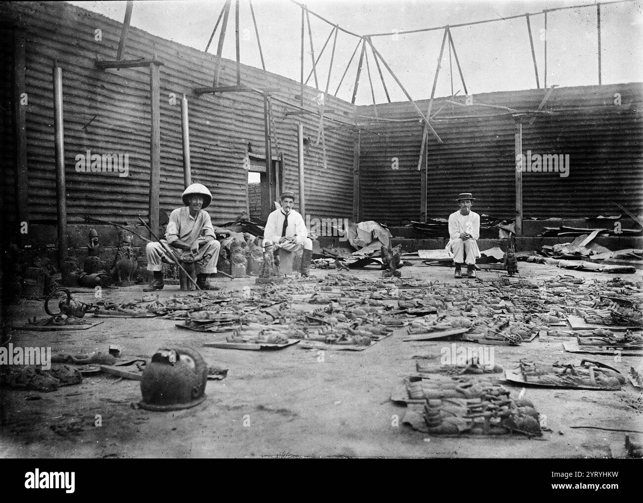 L'interno del complesso di Oba bruciò durante l'assedio di Benin City (attuale Nigeria) , con targhe di bronzo in primo piano e tre soldati britannici della spedizione punitiva del Benin il 9-18 febbraio 1897. Fotografo Reginald Granville. Foto Stock