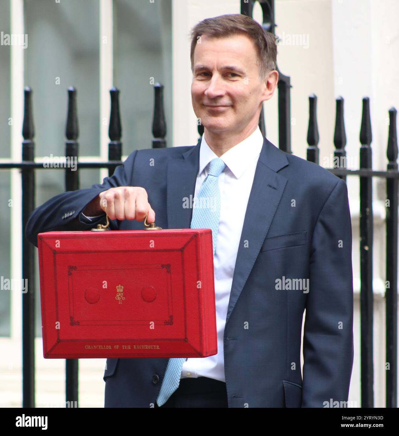 Il cancelliere conservatore britannico Jeremy Hunt in piedi con la sua valigia rossa mentre parte per il Parlamento da Downing Street a Londra, per consegnare il bilancio di primavera, marzo 2024. Foto Stock