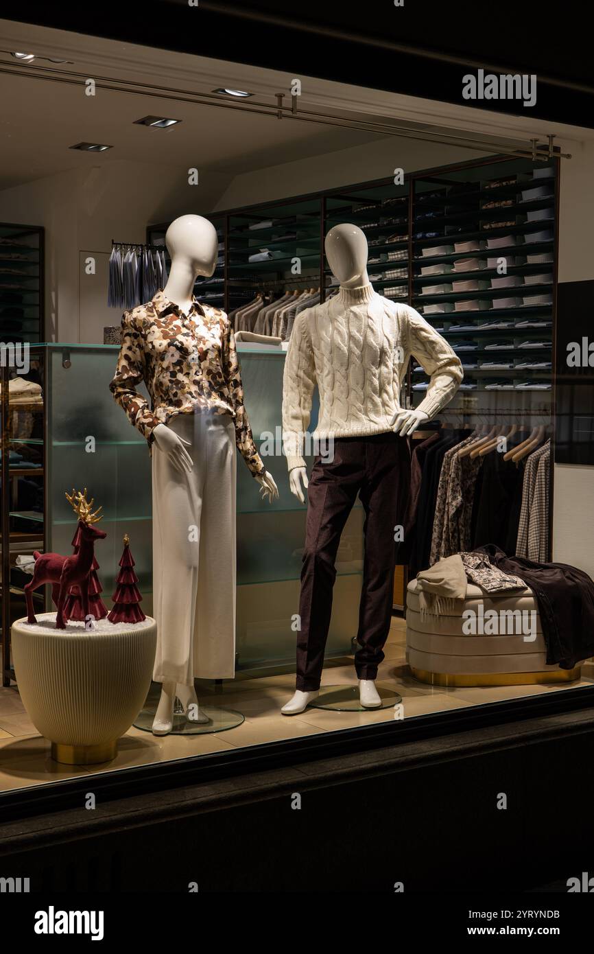 Manichini femminili e maschili in vetrina in stile casual autunno - abbigliamento elegante invernale, scena notturna Foto Stock