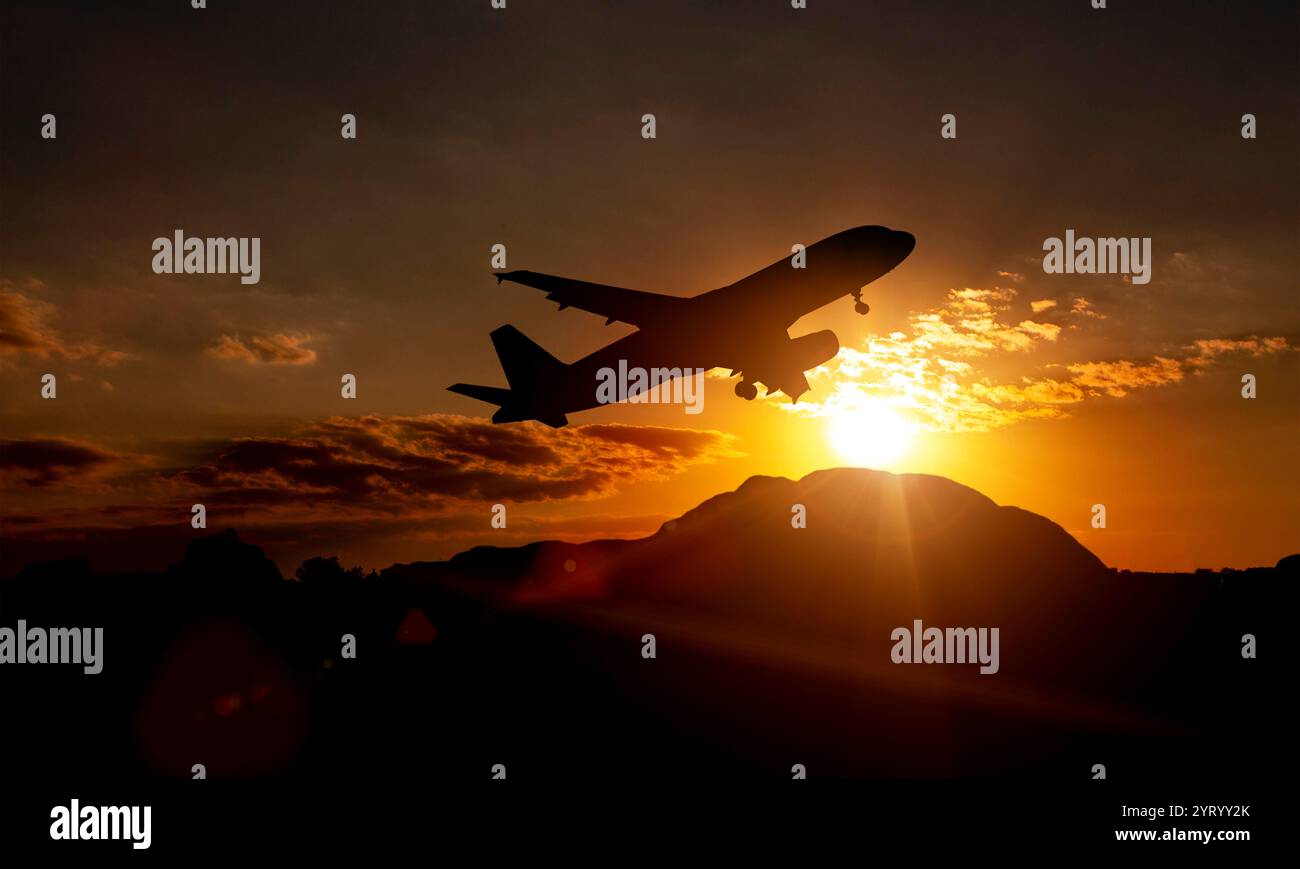 Passeggeri aerei commerciali che volano sopra le nuvole alla luce del tramonto. Concetto di viaggi veloci, vacanze e affari. Sorvolate le montagne al tramonto Foto Stock