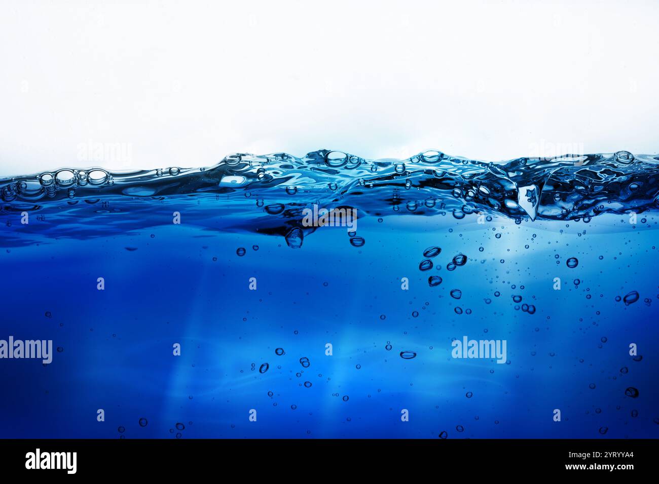 Le bolle d'acqua galleggiano sotto gli schizzi d'acqua su sfondo bianco. Mare calmo sotto un cielo blu all'alba. linea d'acqua. superficie dell'acqua di mare . Spruzzi d'acqua blu Foto Stock