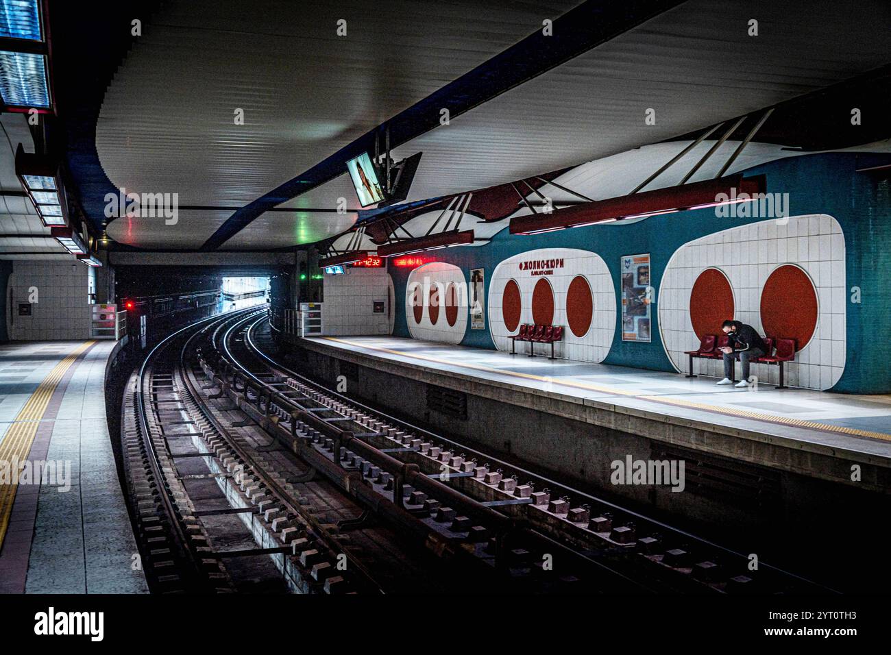 La stazione della metropolitana di Sofia "P. Joliot-Curie" presenta un design moderno con pareti circolari uniche, binari illuminati e passeggeri in attesa sul PL Foto Stock
