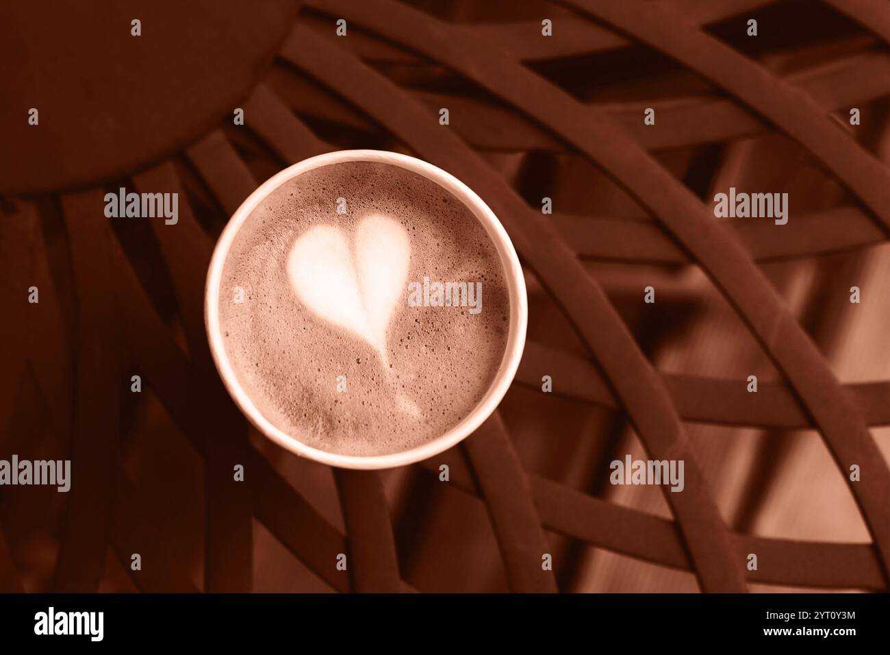 Caffè in tazza di carta su un tavolo in metallo vintage marrone. Vista dall'alto. Dimostrazione del colore dell'anno 2025 - Mocha Mousse. Foto Stock