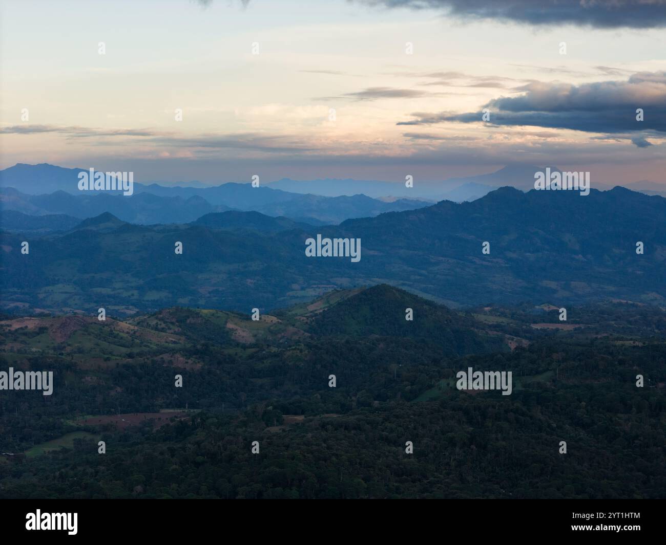 Paesaggio di campagna montana collinare con vista aerea dei droni alla luce del tramonto Foto Stock