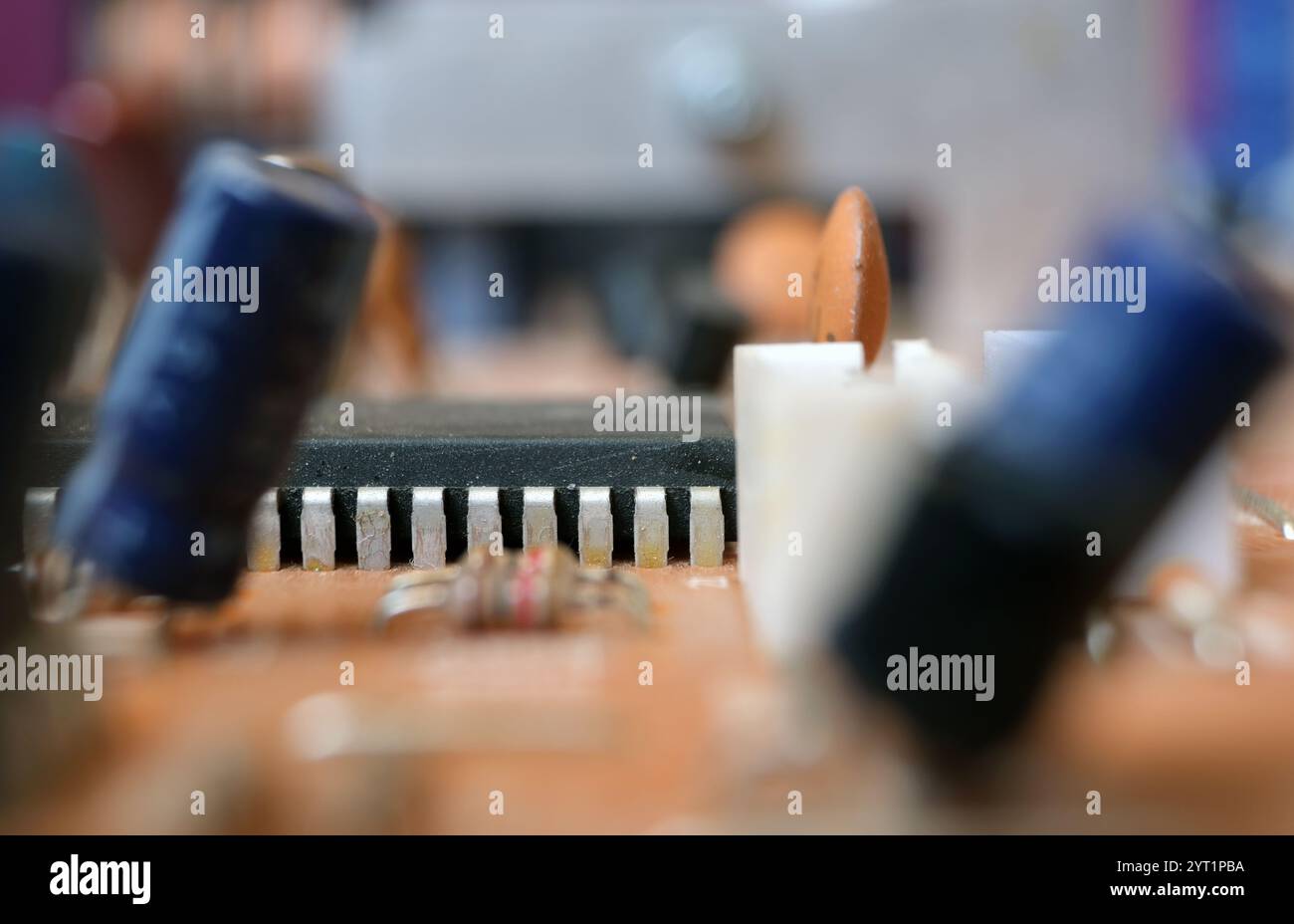 Vista parziale di un circuito integrato o IC su una scheda elettronica. Focalizzato sui pin del componente semiconduttore. Foto Stock