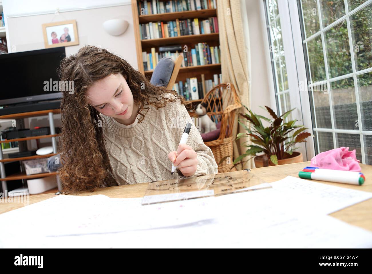 Adolescente che studia revisione della struttura cellulare biologia scientifica GCSE disegnando il diagramma della cellula sulla lavagna bianca Foto Stock