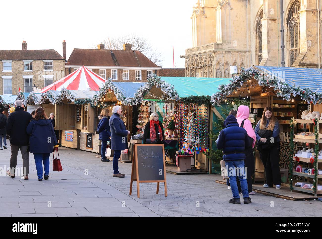 Un mercatino di Natale che risale a 600 anni fa è tornato ai giardini della Cattedrale di Canterbury per la prima volta in 200 anni, con giostra e chalet. Foto Stock