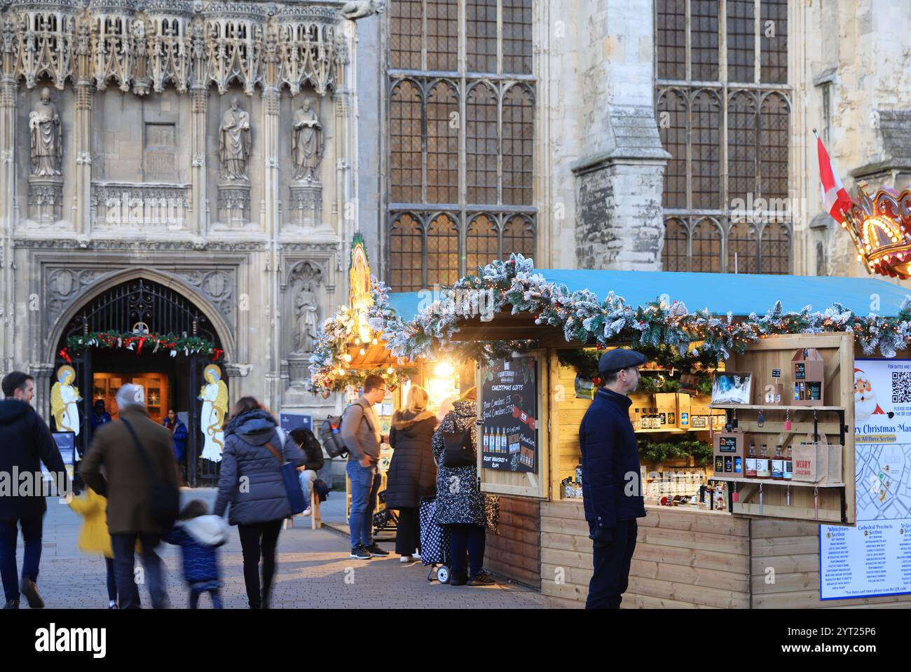 Un mercatino di Natale che risale a 600 anni fa è tornato ai giardini della Cattedrale di Canterbury per la prima volta in 200 anni, con giostra e chalet. Foto Stock