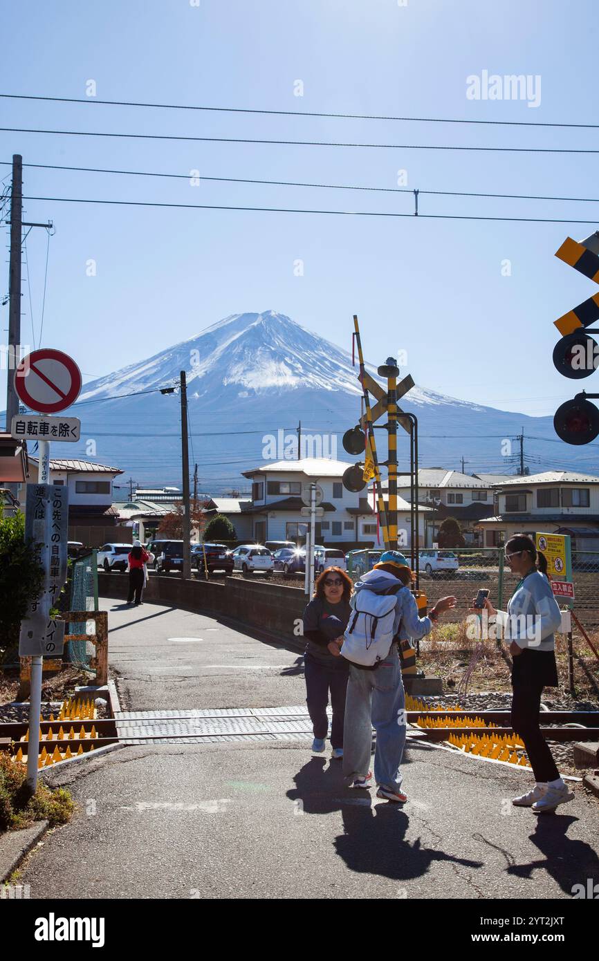 Turisti su una piccola strada e in treno vicino alla stazione di Kawaguchiko a Yamanashi, Giappone, per scattare selfie e scattare fotografie del Monte Fuji. Foto Stock