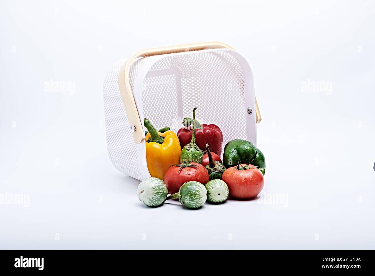 Verdure sane e frutta fresca dal cesto sono fotografate su sfondo bianco e macinato Foto Stock