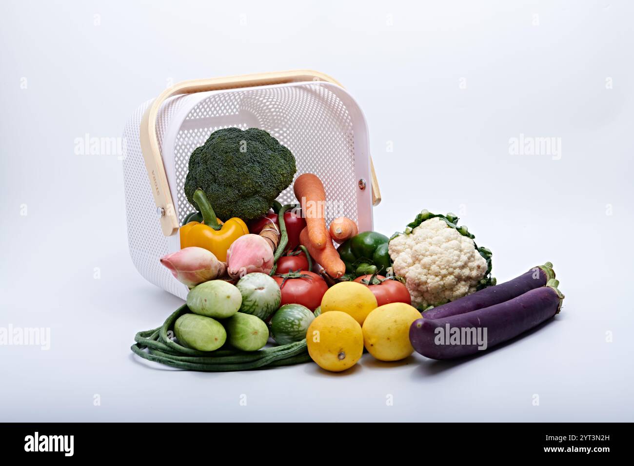 Verdure sane e frutta fresca dal cesto sono fotografate su sfondo bianco e macinato Foto Stock