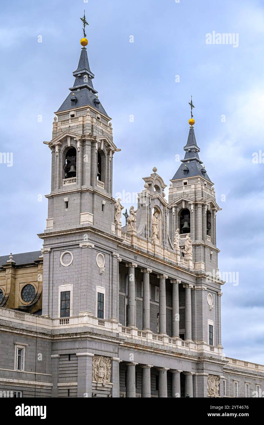 Facciata della Cattedrale dell'Almudena sotto un cielo coperto. Foto Stock