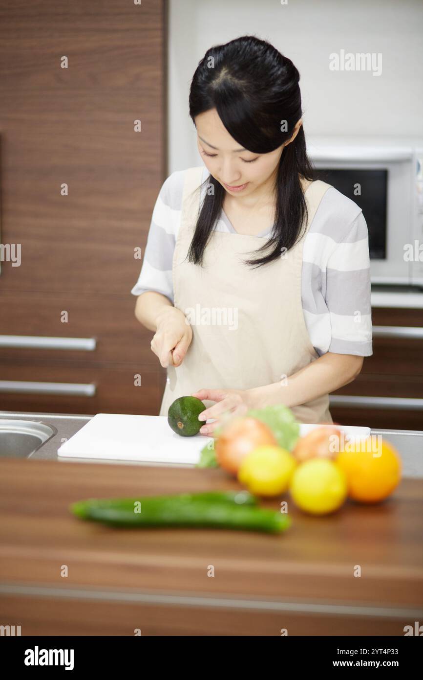 Giovane casalinga in piedi in cucina Foto Stock