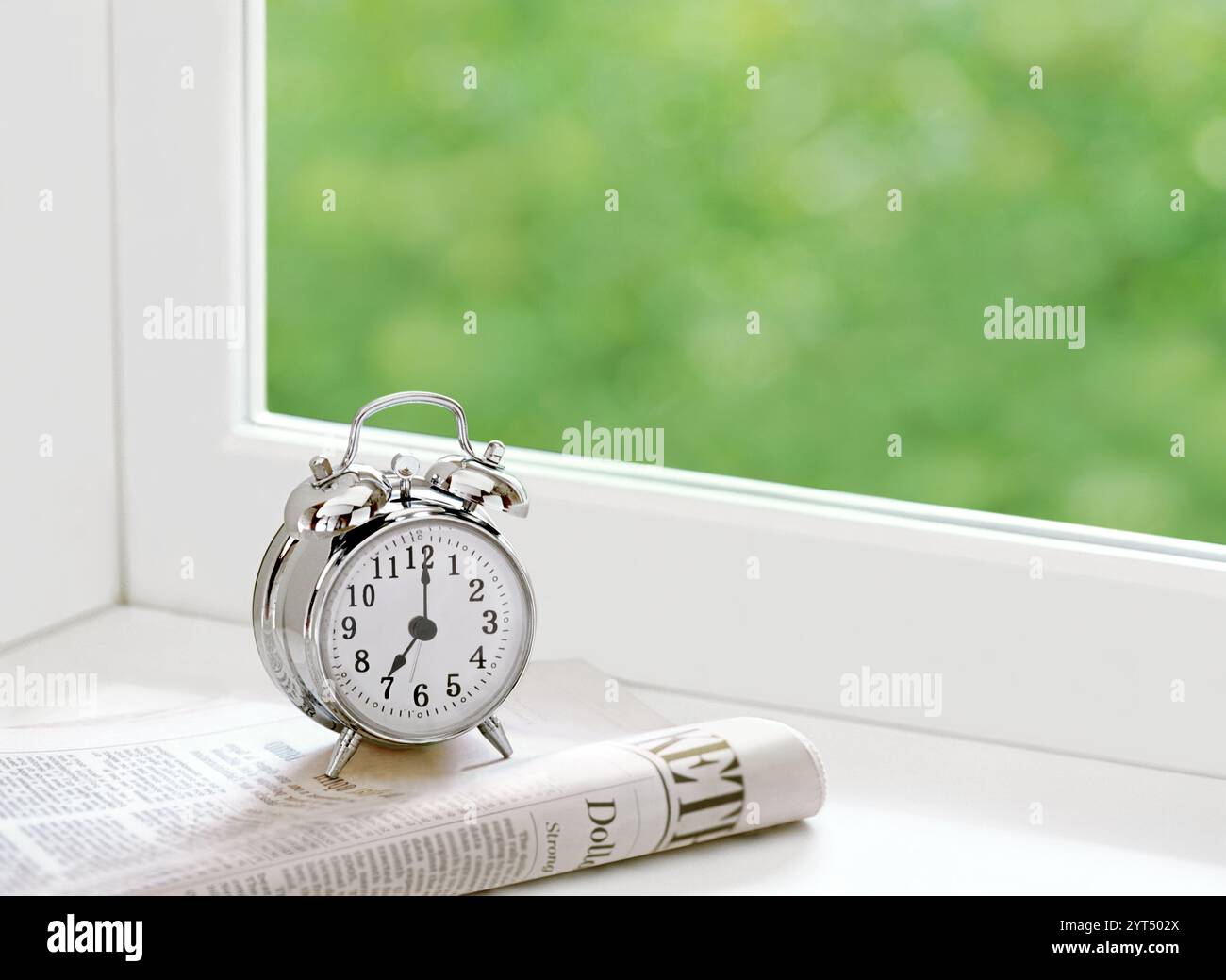 Sveglia e quotidiano sul davanzale Foto Stock