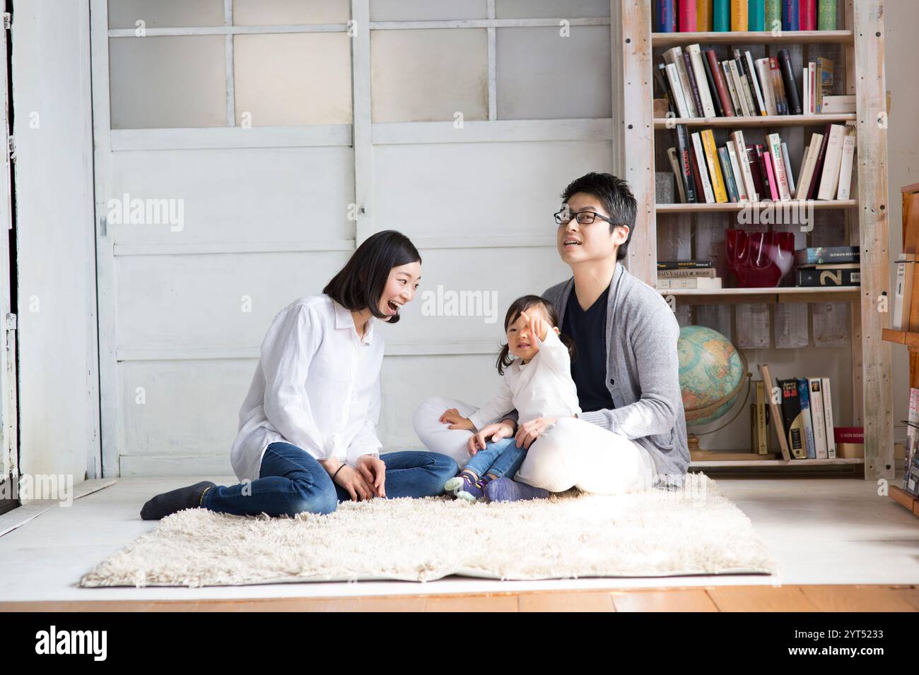 Famiglia di tre persone che si divertono nel soggiorno Foto Stock