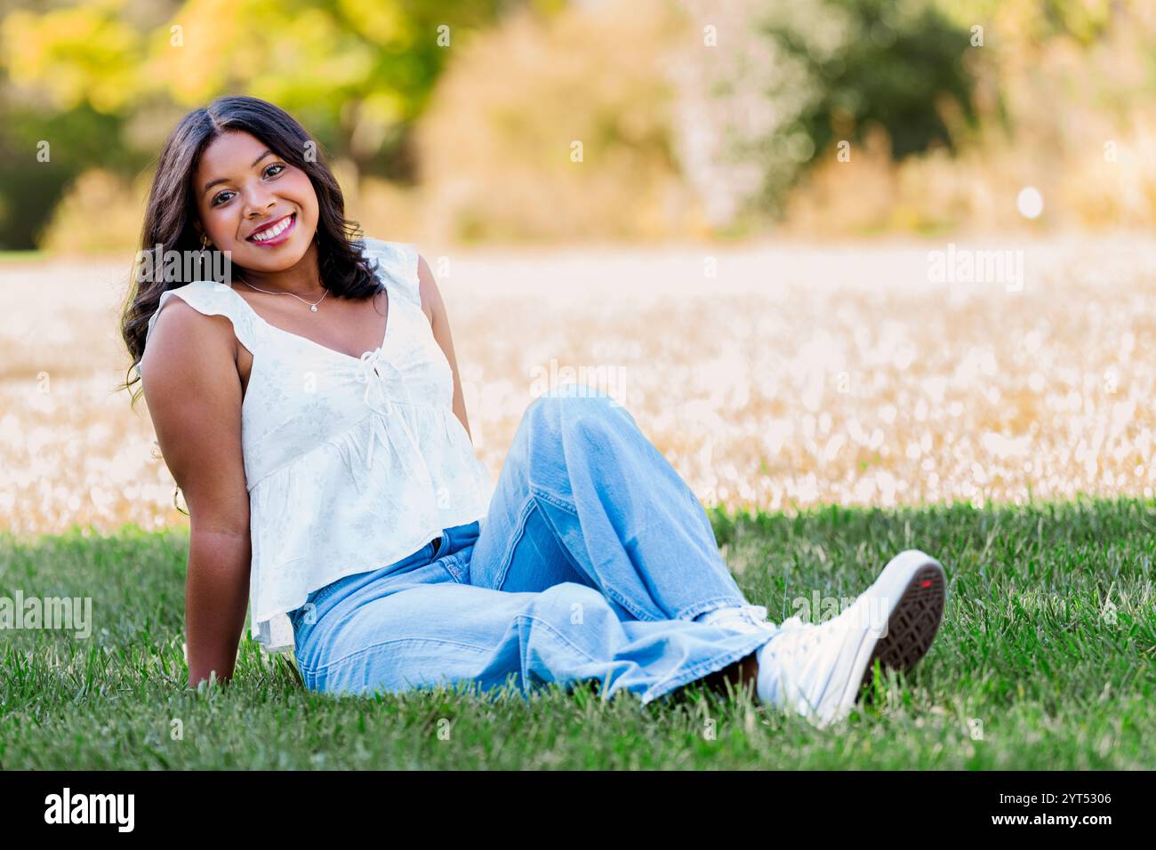 Modello afroamericano in posa nell'erba Foto Stock