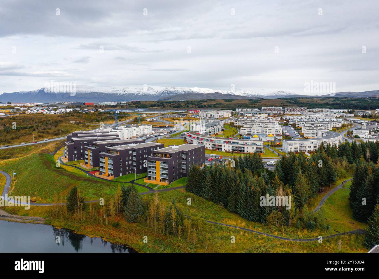 Città moderna con vegetazione e lago Foto Stock