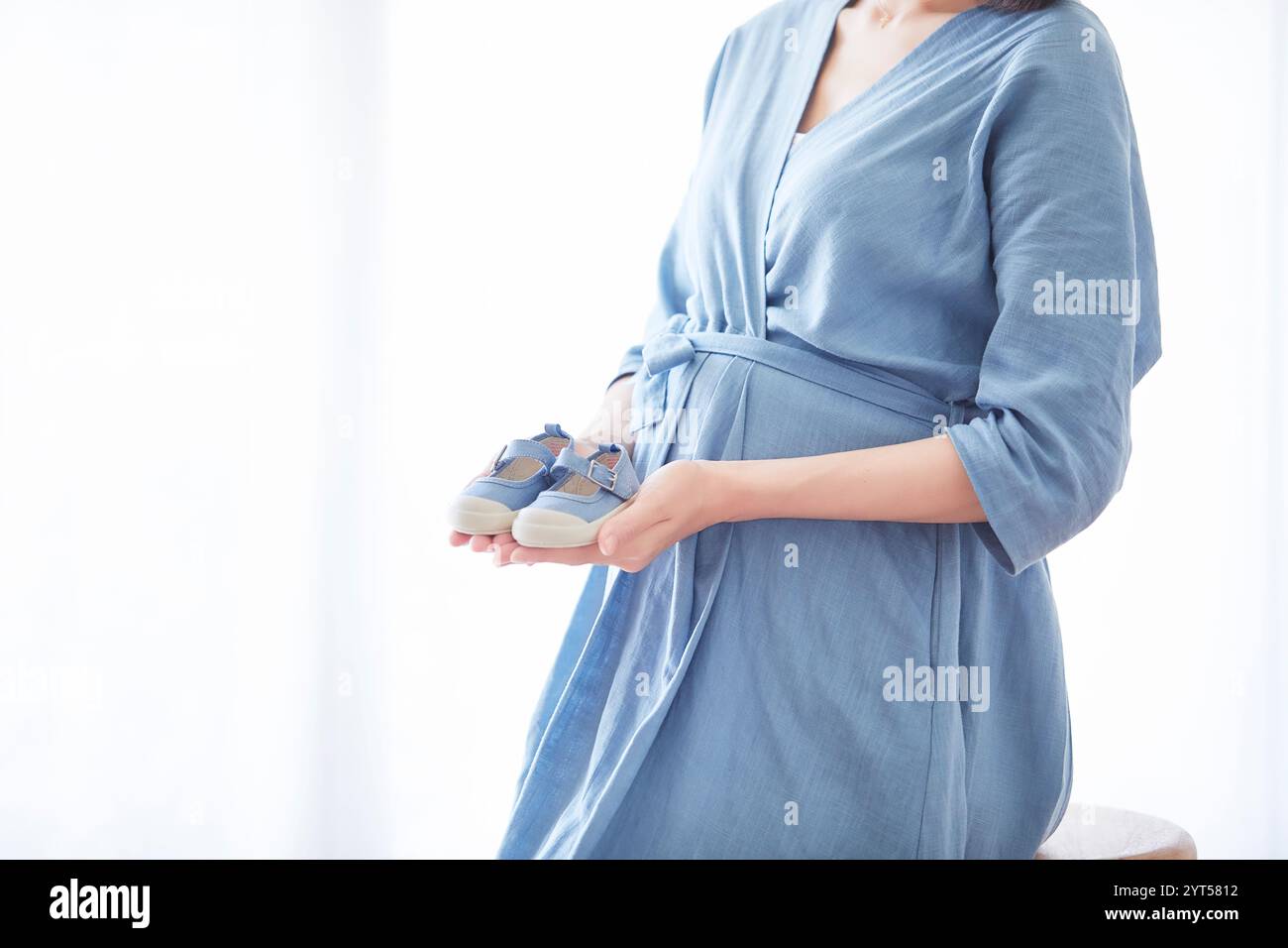 Donna che mantiene il bambino scarpe Foto Stock