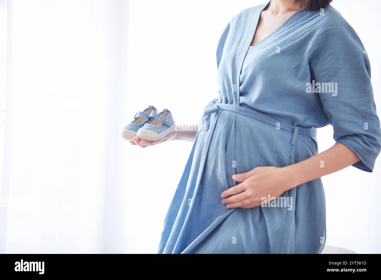 Donna che mantiene il bambino scarpe Foto Stock