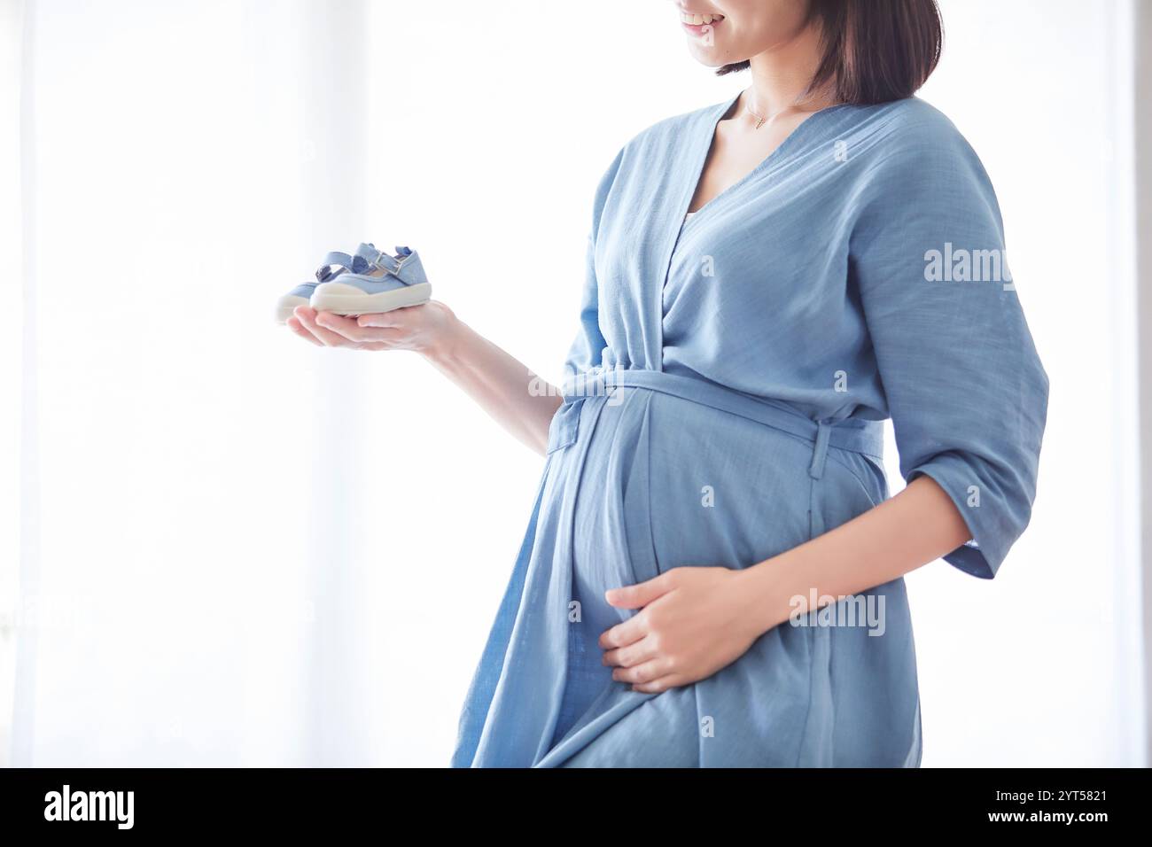 Donna che mantiene il bambino scarpe Foto Stock