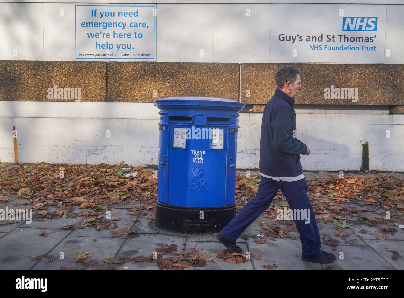 Londra, Regno Unito. 6 dicembre 2024 Un pedone passa davanti a una cassetta postale dipinta in blu come ringraziamento al NHS fuori dall'ospedale St Thomas a Westminster. Il servizio sanitario nazionale sta affrontando un quad-demic sanitario quest'inverno, poiché il numero di persone ricoverate in ospedale con influenza è aumentato del 350%, esercitando una pressione significativa sul servizio sanitario nazionale a causa dell'aumento dei casi di influenza e covid rispetto al credito dello scorso anno. Amer Ghazzal/Alamy Live News Foto Stock