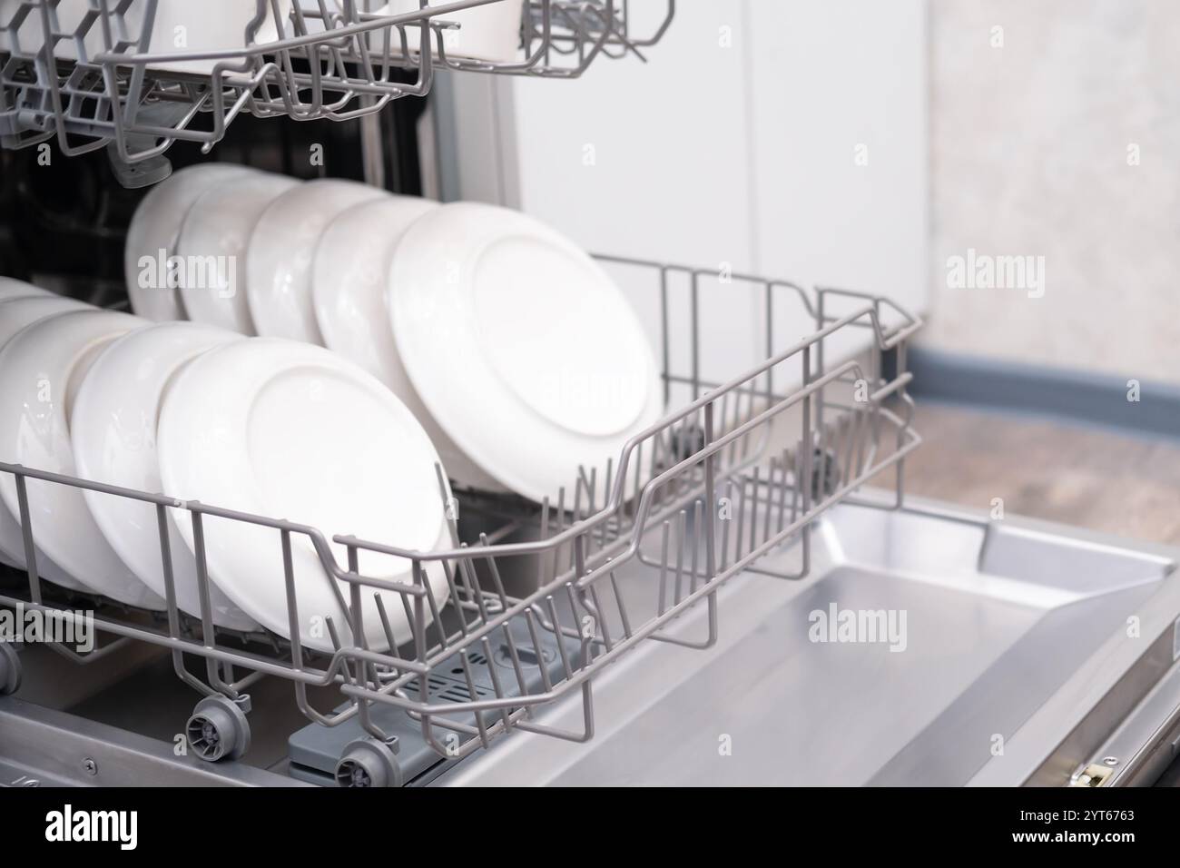 Sportello della lavastoviglie incorporato aperto. Cucina con elettrodomestici incorporati. Piatti e piatti sono lavabili in lavastoviglie. Foto Stock