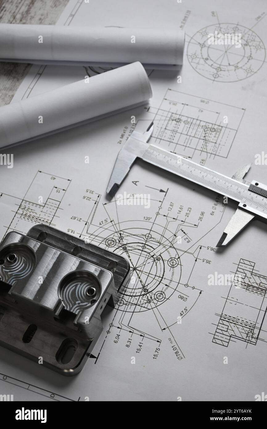 Parti metalliche lavorate su un disegno tecnico con un calibro, che mostra l'ingegneria e la produzione di precisione. Foto Stock