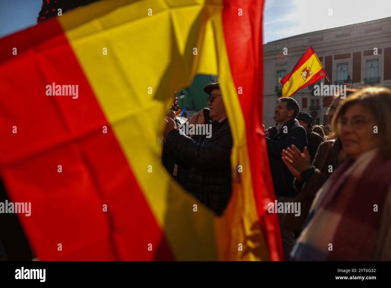Madrid, Spagna. 6 dicembre 2024. Una bandiera spagnola con un buco nel centro vola a Puerta del Sol durante una manifestazione organizzata da attivisti di estrema destra a Puerta del Sol, chiedendo una giornata di non costituzione. Oggi, 6 dicembre, la Spagna commemora il 46° anniversario della Costituzione spagnola. Crediti: D. Canales Carvajal/Alamy Live News Foto Stock