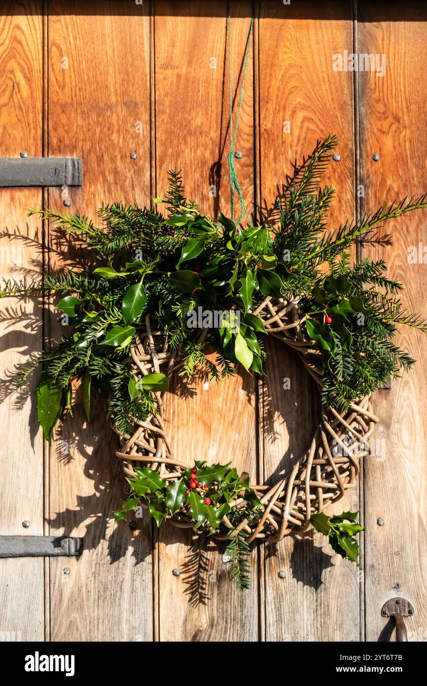 Ghirlande natalizie sulle porte d'ingresso nel villaggio di Lacock, nel wiltshire, UK Foto Stock