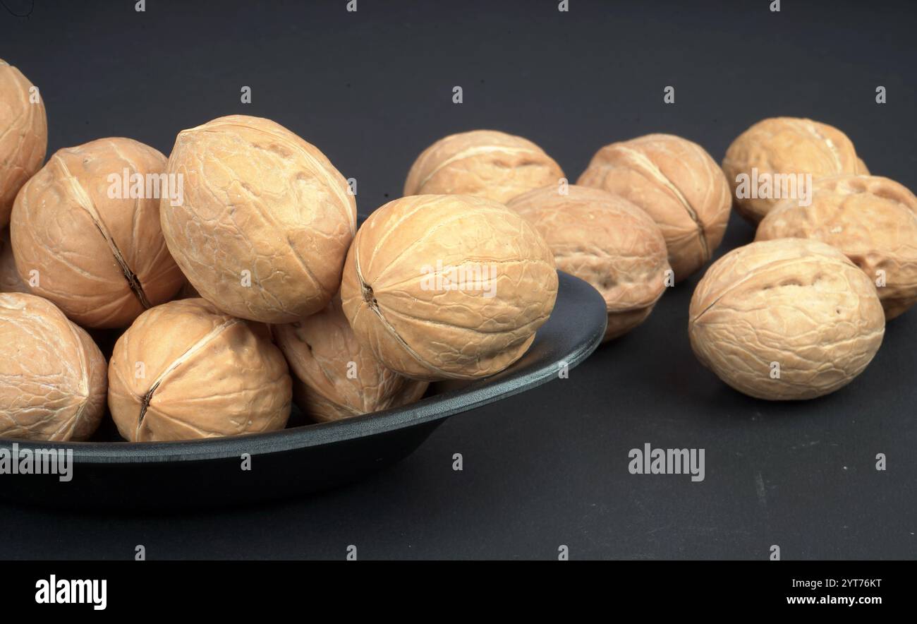 Noce fresca di qualità in piatto nero e fondo Foto Stock