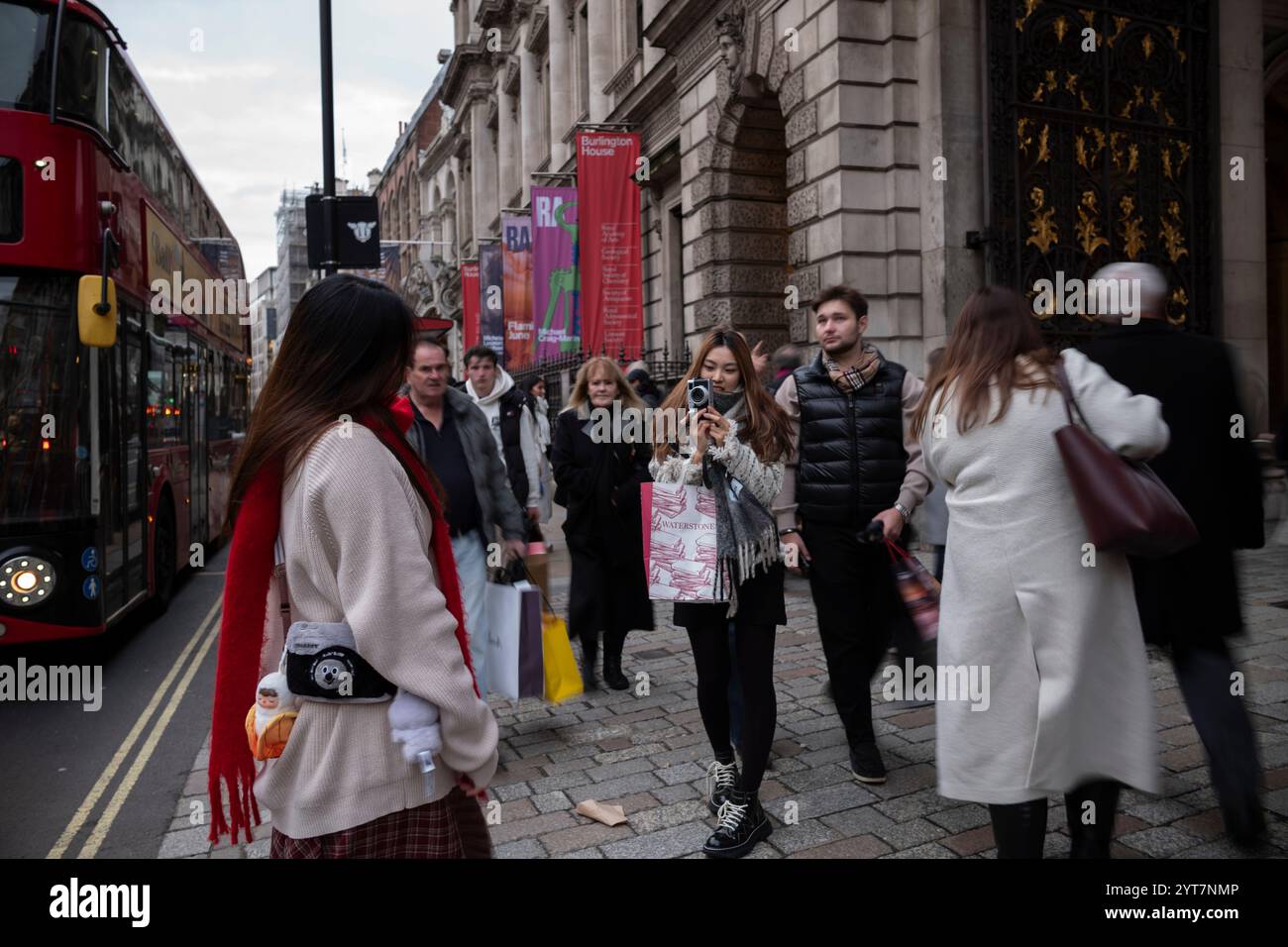 Vita quotidiana in una delle strade più iconiche di Londra, Piccadilly, nel centro di Londra, durante un pomeriggio invernale mentre pendolari e turisti si recano. Foto Stock