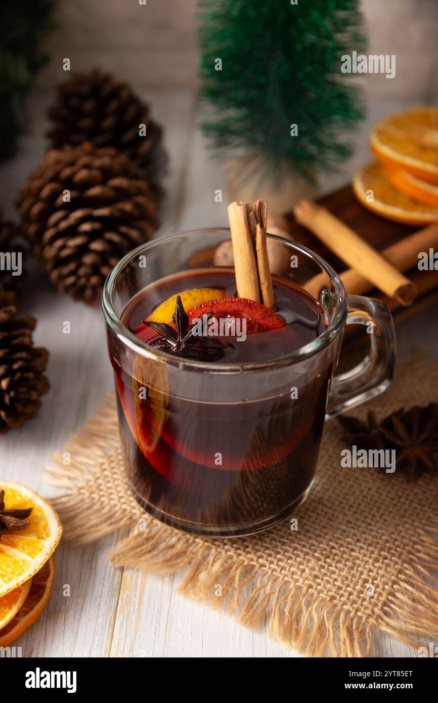 Vino speziato o VIN brulé di Natale con arancia, cannella, anice stellato, chiodi di garofano, noce moscata e altri ingredienti su un tavolo rustico in legno. Caldo tradizionale Foto Stock