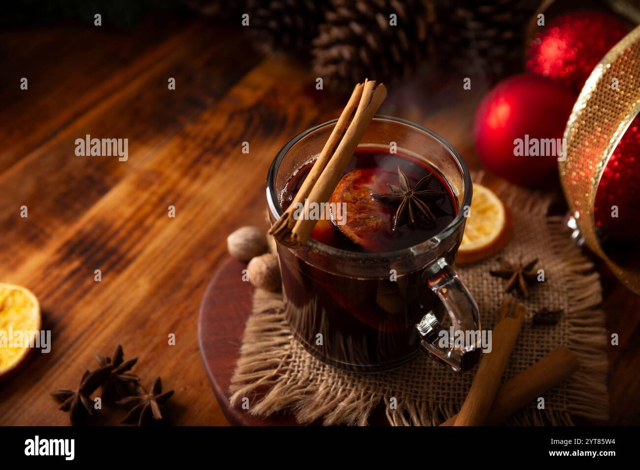 Vino speziato o VIN brulé di Natale con arancia, cannella, anice stellato, chiodi di garofano, noce moscata e altri ingredienti su un tavolo rustico in legno. Caldo tradizionale Foto Stock