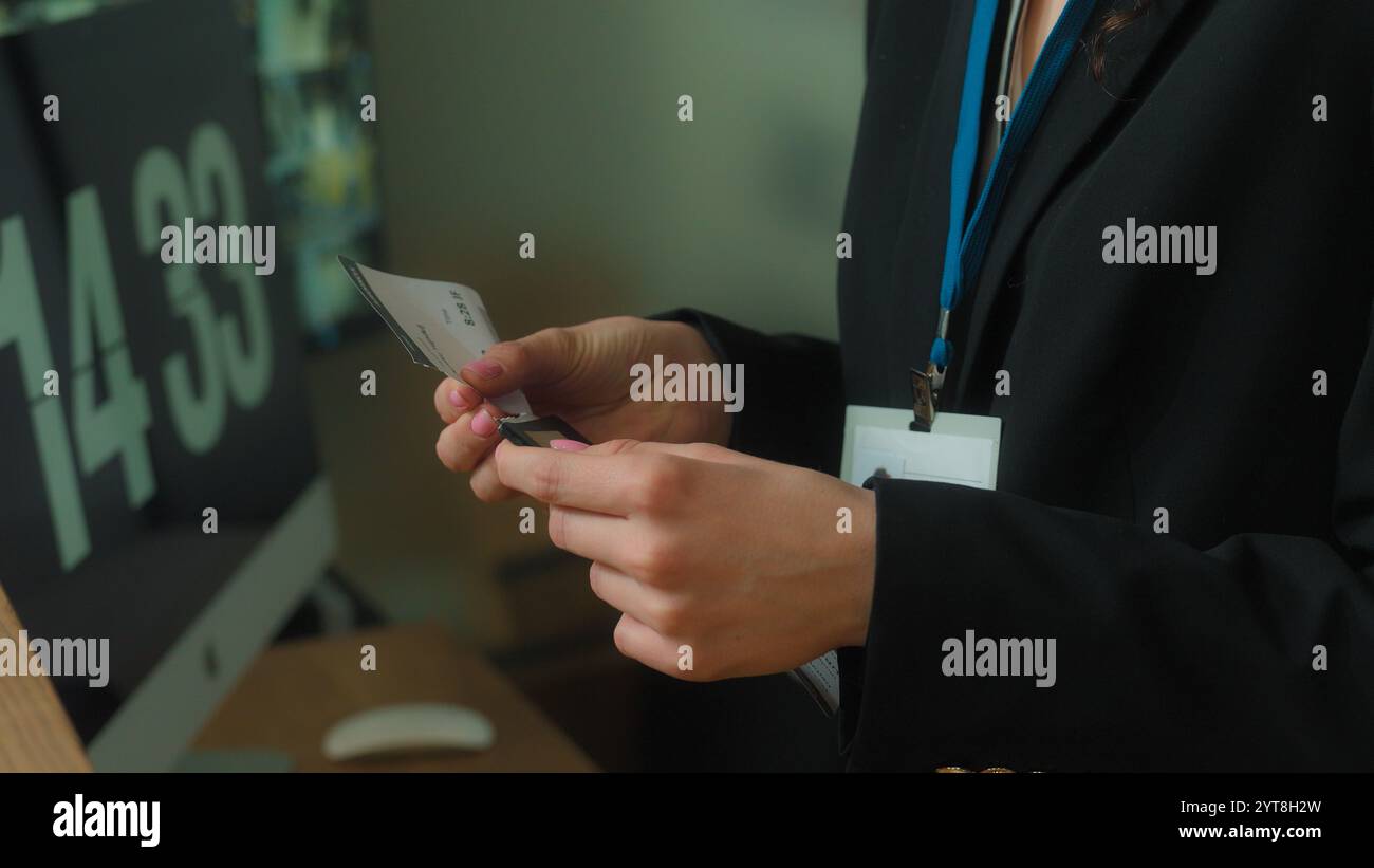 Donna irriconoscibile concierge operaio reception dell'hotel dare il controllo dei biglietti aerei servizio di registrazione passaporto viaggiatore turista arrivo passeggero Foto Stock