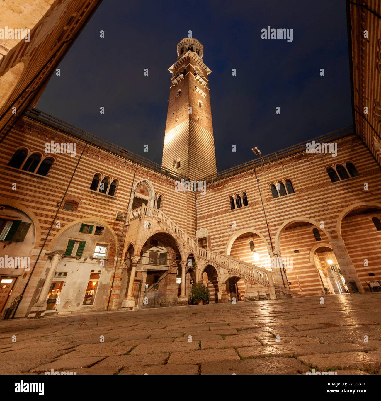 Il cortile del Palazzo della ragione di Verona di sera, illuminato da lampioni Foto Stock