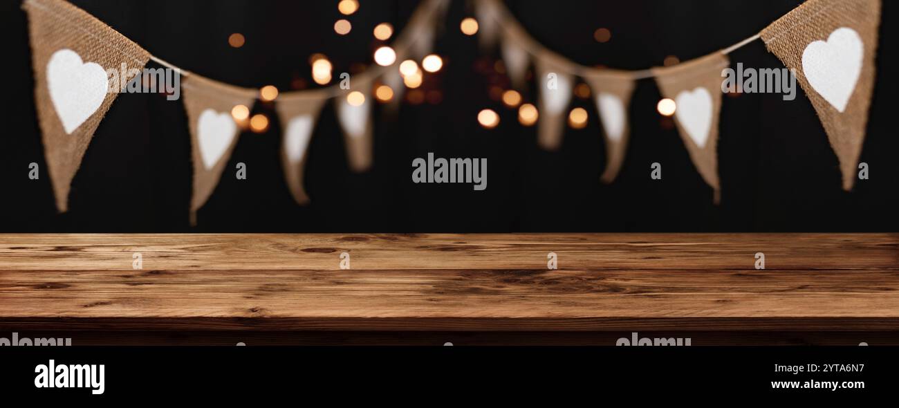 Appeso all'aperto per feste in stile boho con luci dorate e bancone in legno vuoto. Sfondo orizzontale per feste serali estive con spazio per decorazioni. Foto Stock