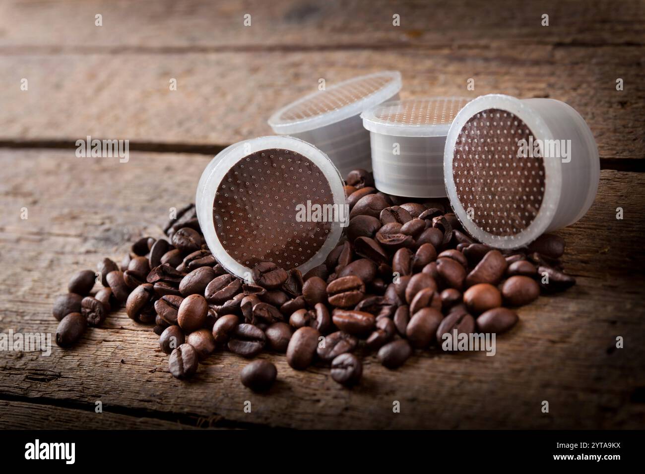 I chicchi di caffè con cialde sul tavolo di legno Foto Stock