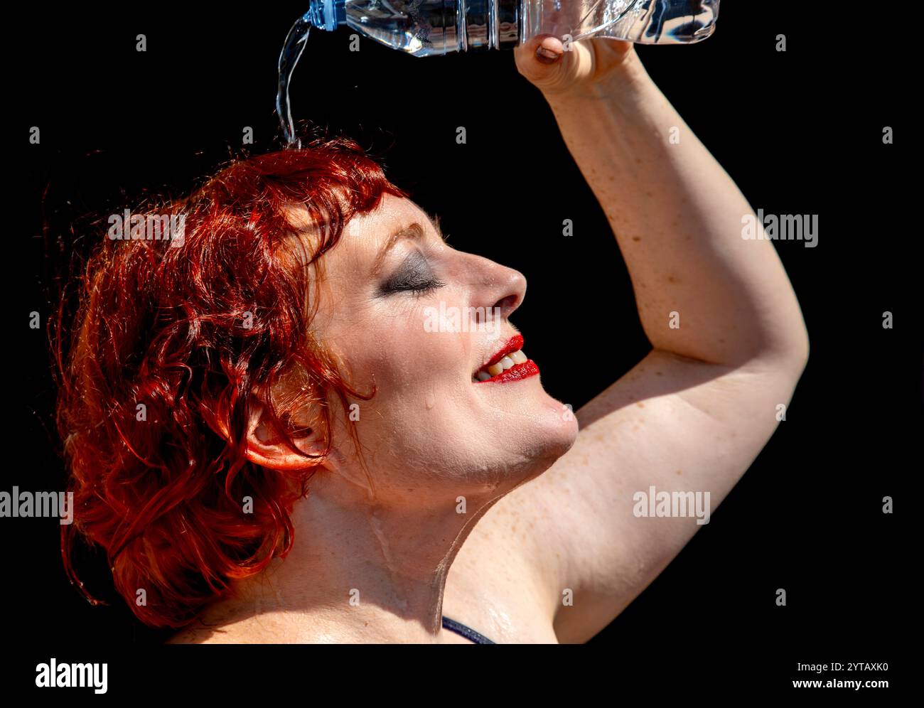 Donna che si raffredda versando acqua sulla testa. Foto Stock