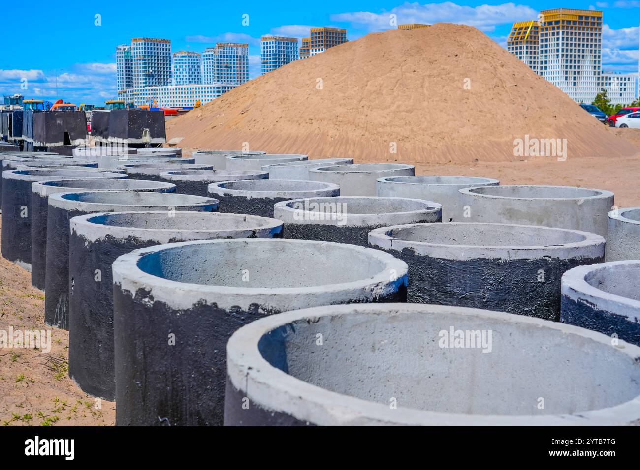 Tubi per fognature in cemento armato grandi diametri di cantieri impilati di grande diametro, sabbia e ghiaia a pelo successivo, materiale di drenaggio per costruzioni in violazione Foto Stock