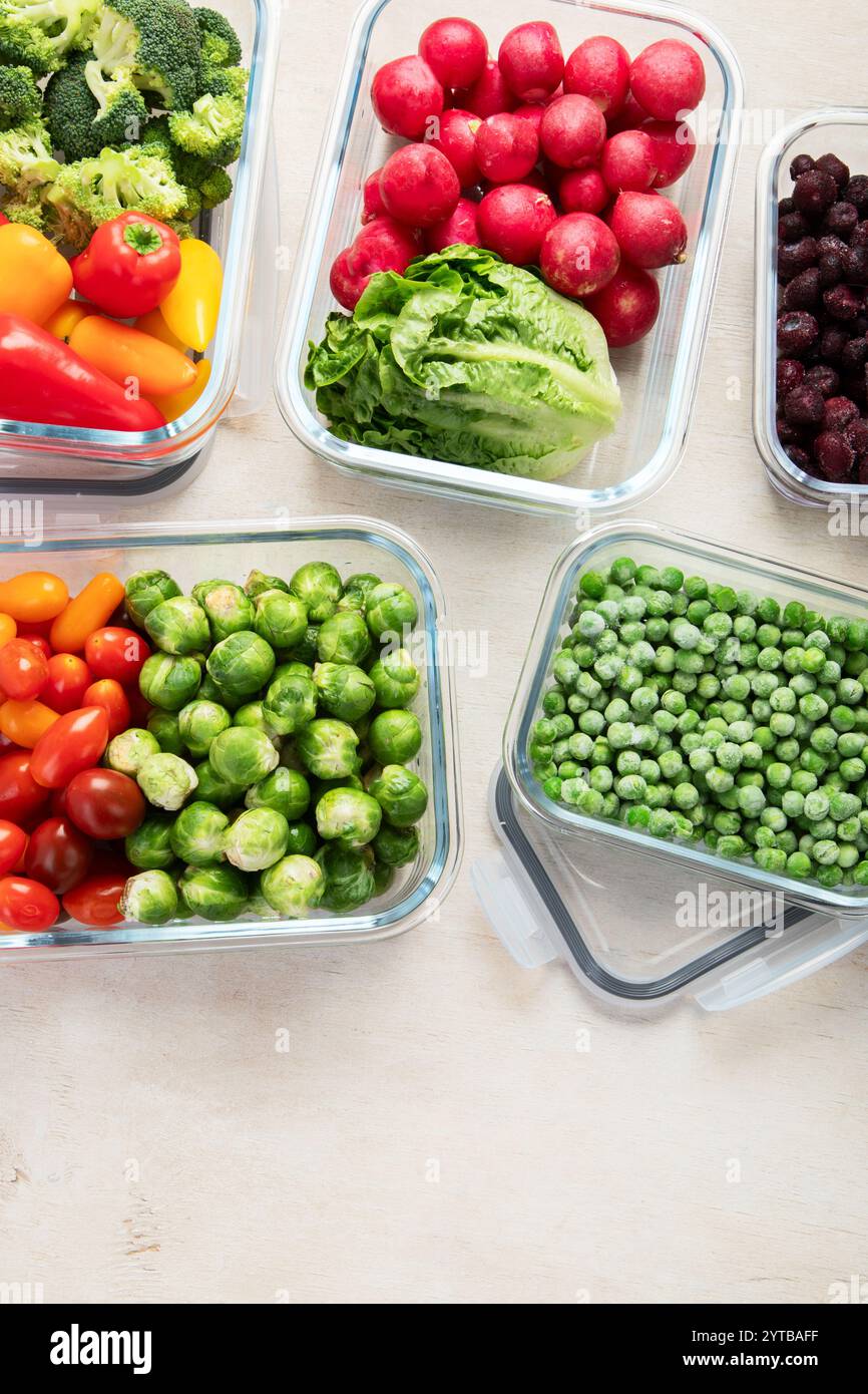 Contenitori in vetro con diversi prodotti freschi, come verdura e frutta, su uno sfondo chiaro. Vista dall'alto. Copia spazio. Foto Stock