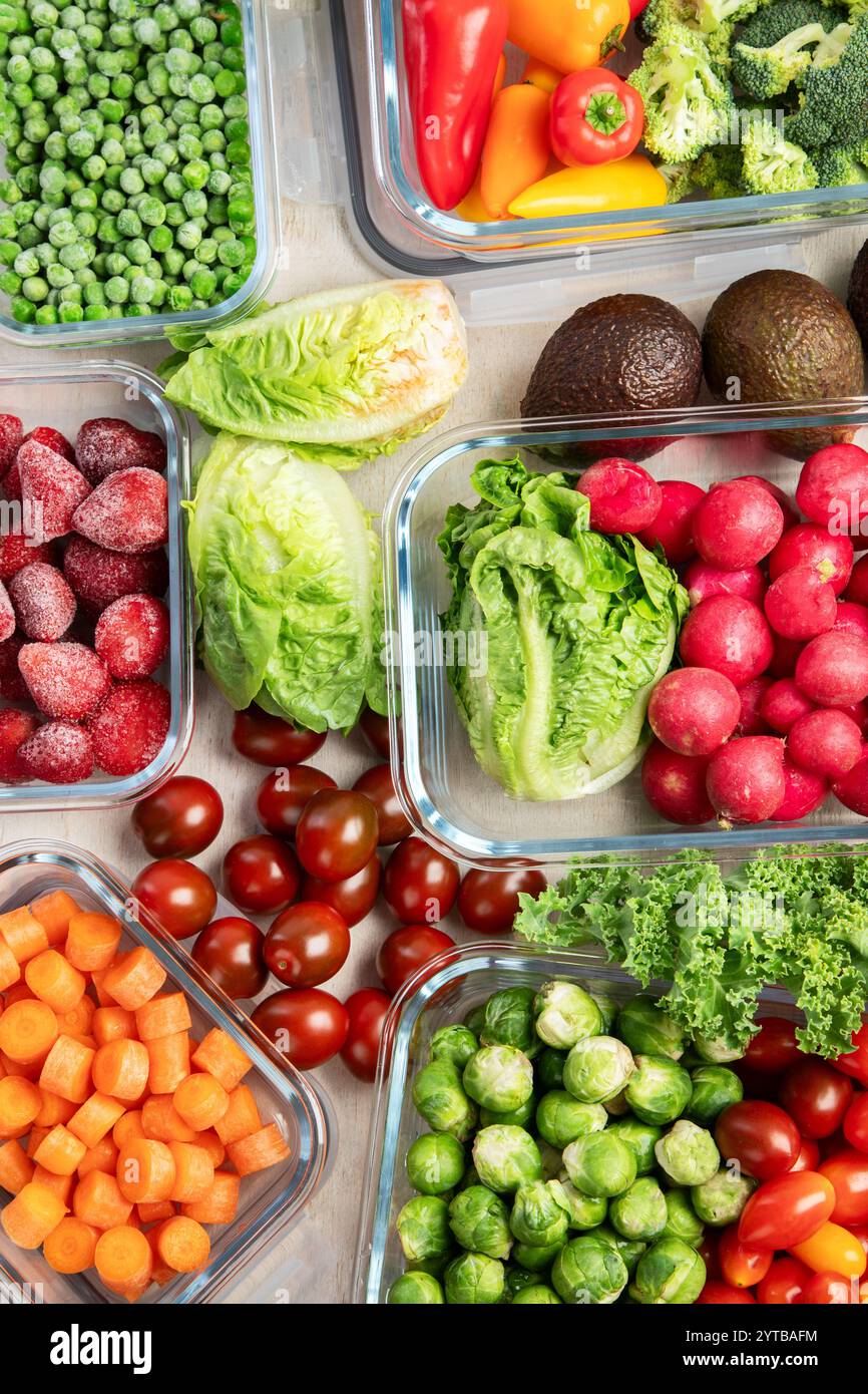 Contenitori in vetro con diversi prodotti freschi, come verdura e frutta, su uno sfondo chiaro. Vista dall'alto. Foto Stock