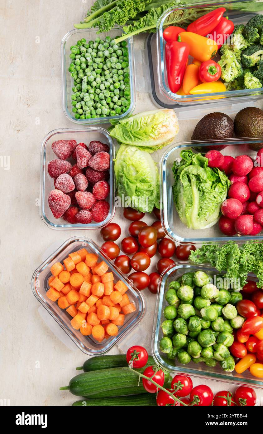 Contenitori in vetro con diversi prodotti freschi, come verdura e frutta, su uno sfondo chiaro. Vista dall'alto. Copia spazio. Foto Stock