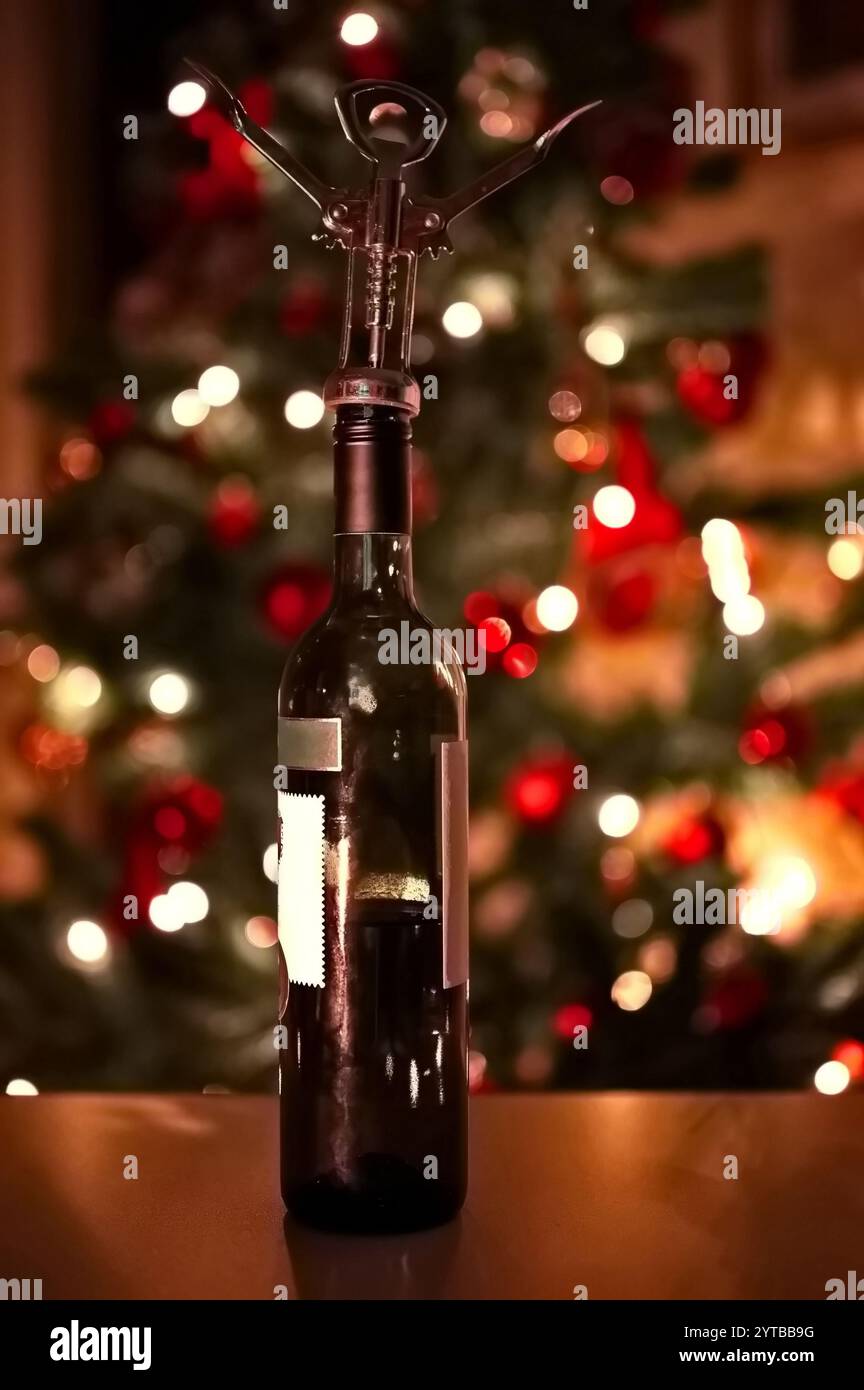 Bottiglia di vino contro l'albero di Natale Foto Stock