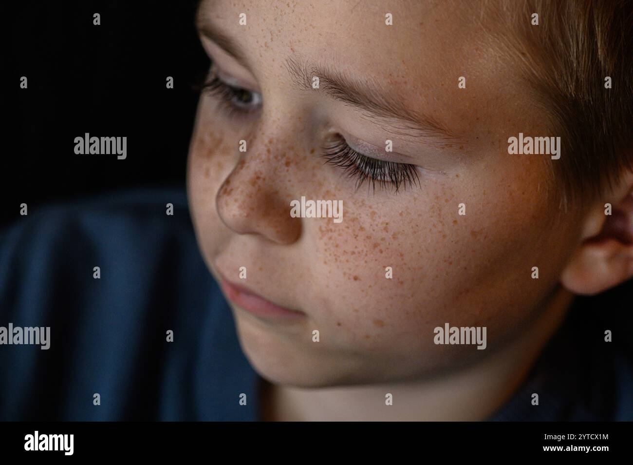 primo piano ritratto ragazzo con lentiggini sulle guance con occhi blu Foto Stock