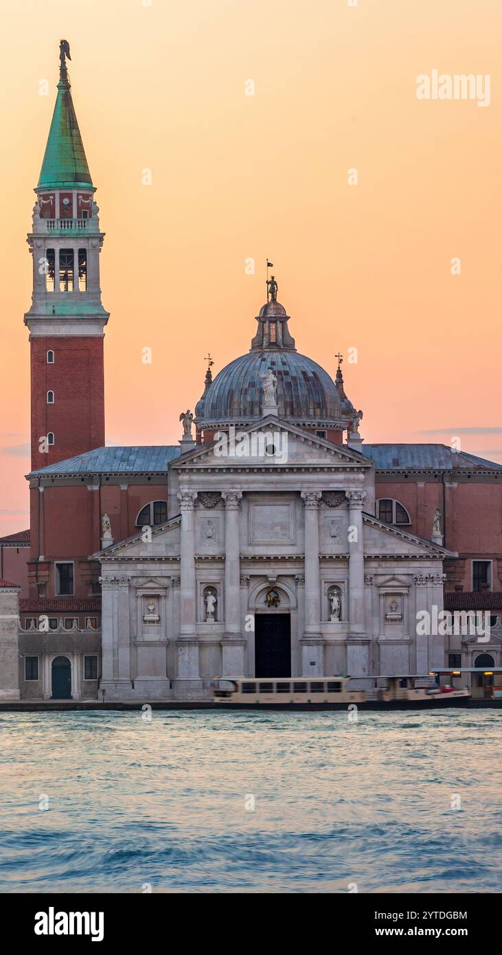 Questa foto cattura Venezia all'alba, con l'iconica chiesa di San Giorgio maggiore e il suo campanile, con acque calme e un morbido rif Foto Stock