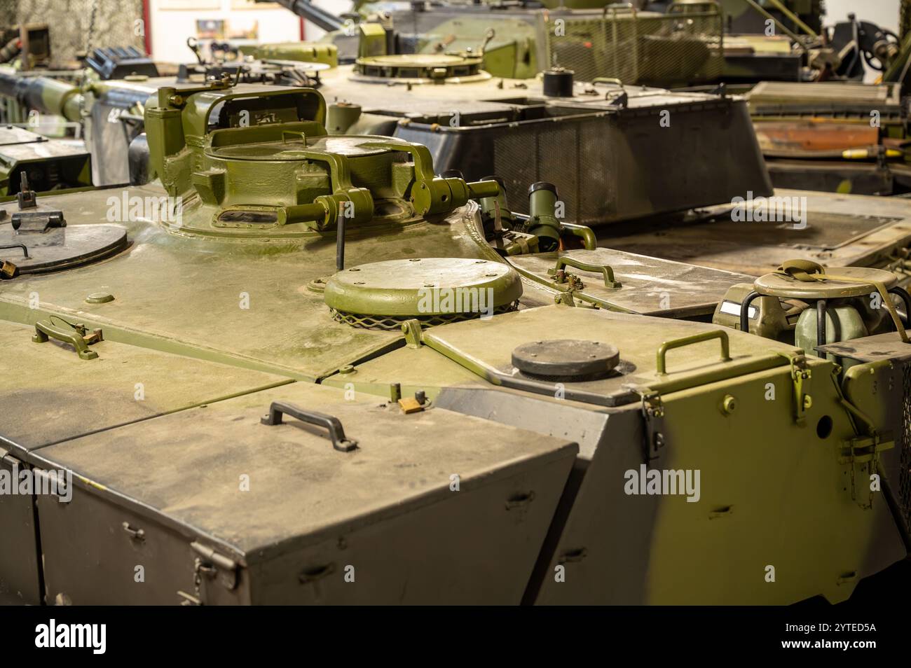 Ammira i carri armati e i veicoli tracciati in un hangar militare di un battaglione corazzato Foto Stock